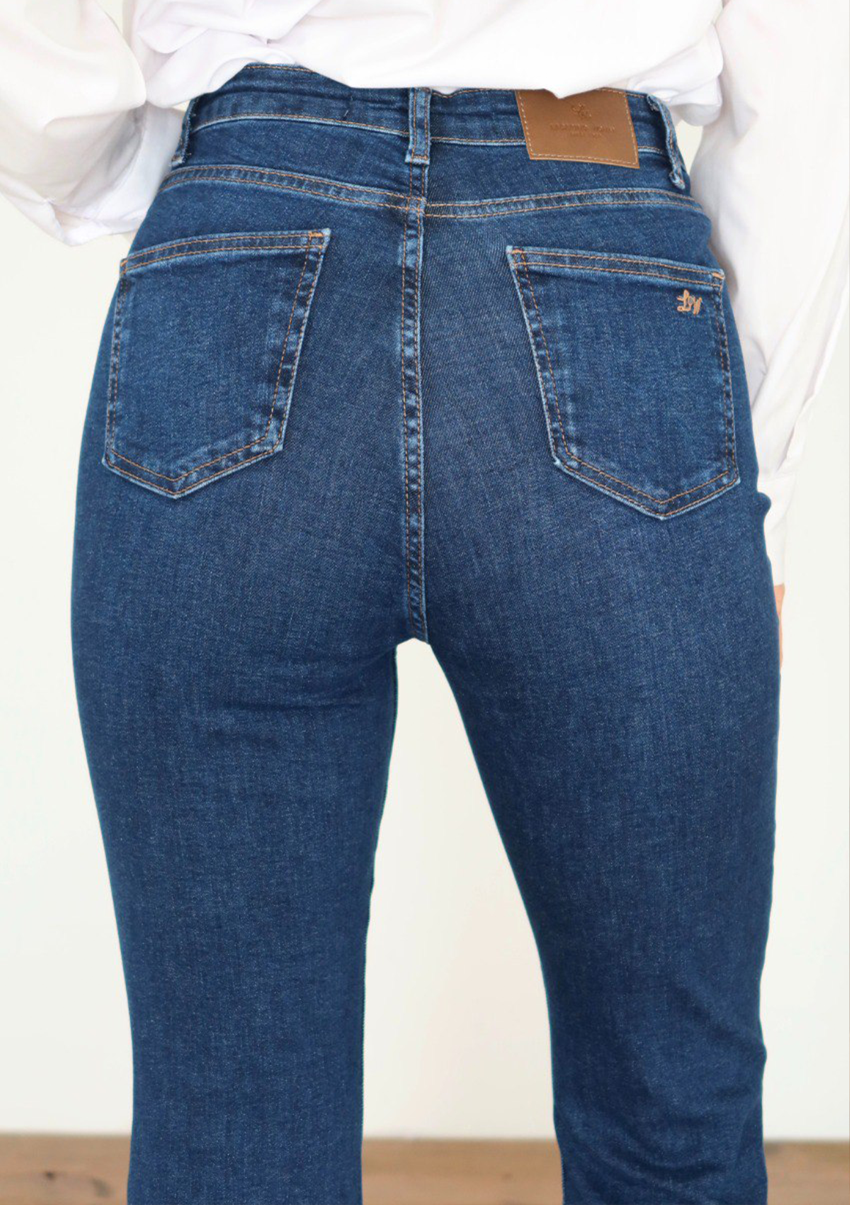 Lara Dark Blue Flare Jean — close up of back pocket detail with contrast stitching in dark blue wash | Mia & Luna